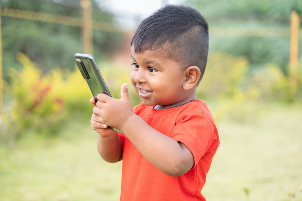 Photo of an excited child holding a smartphone.