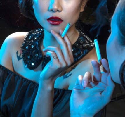 A photograph of a dressed-up woman holding a cigarette and looking in the mirror.