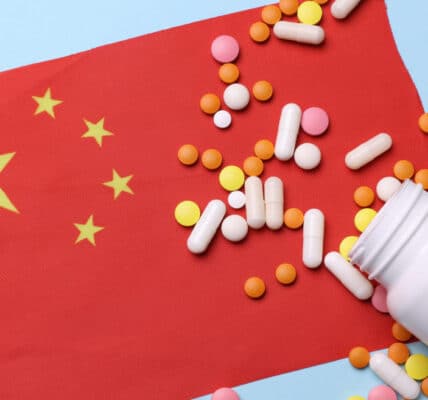 Chinese flag with pill bottle and pills.