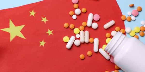 Chinese flag with pill bottle and pills.