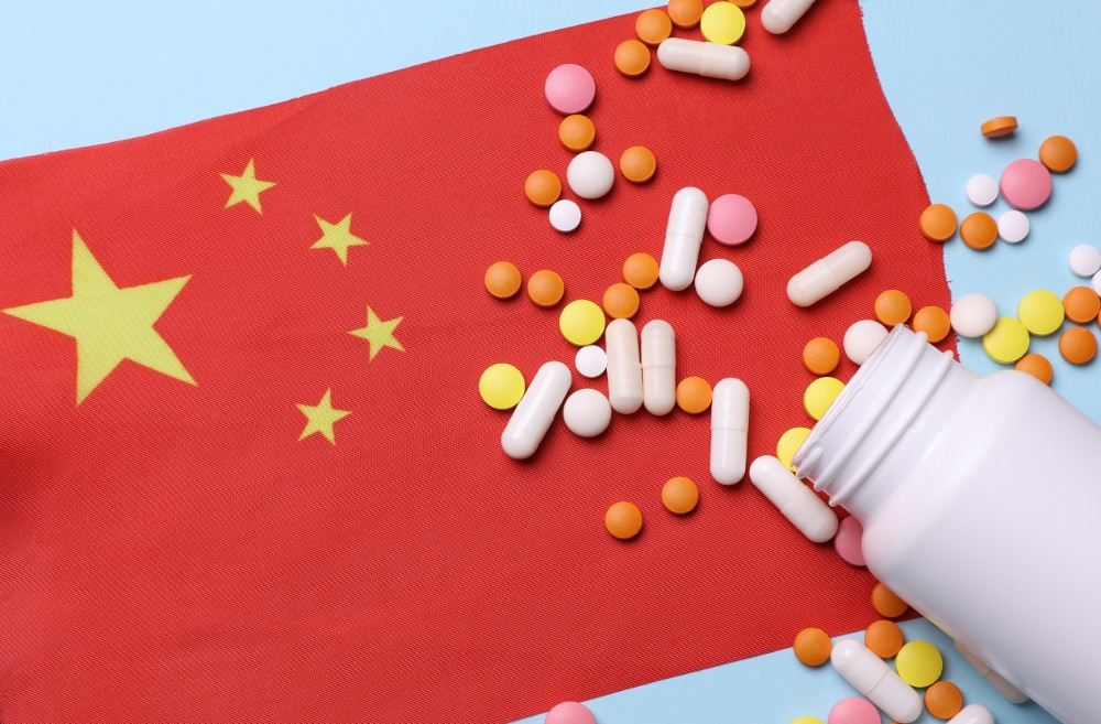 Chinese flag with pill bottle and pills.