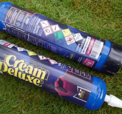 Photo of two nitrous oxide canisters laying in the grass.