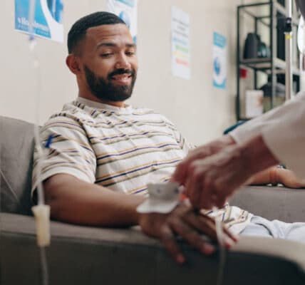 Photo of man receiving pain management drip at a clinic.