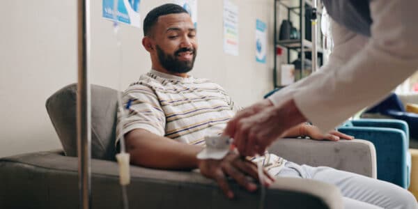 Photo of man receiving pain management drip at a clinic.