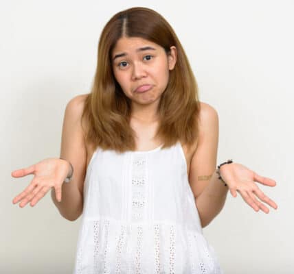 Photo of a young woman holding her hands palms up as if to indicate indecision or six-seven.