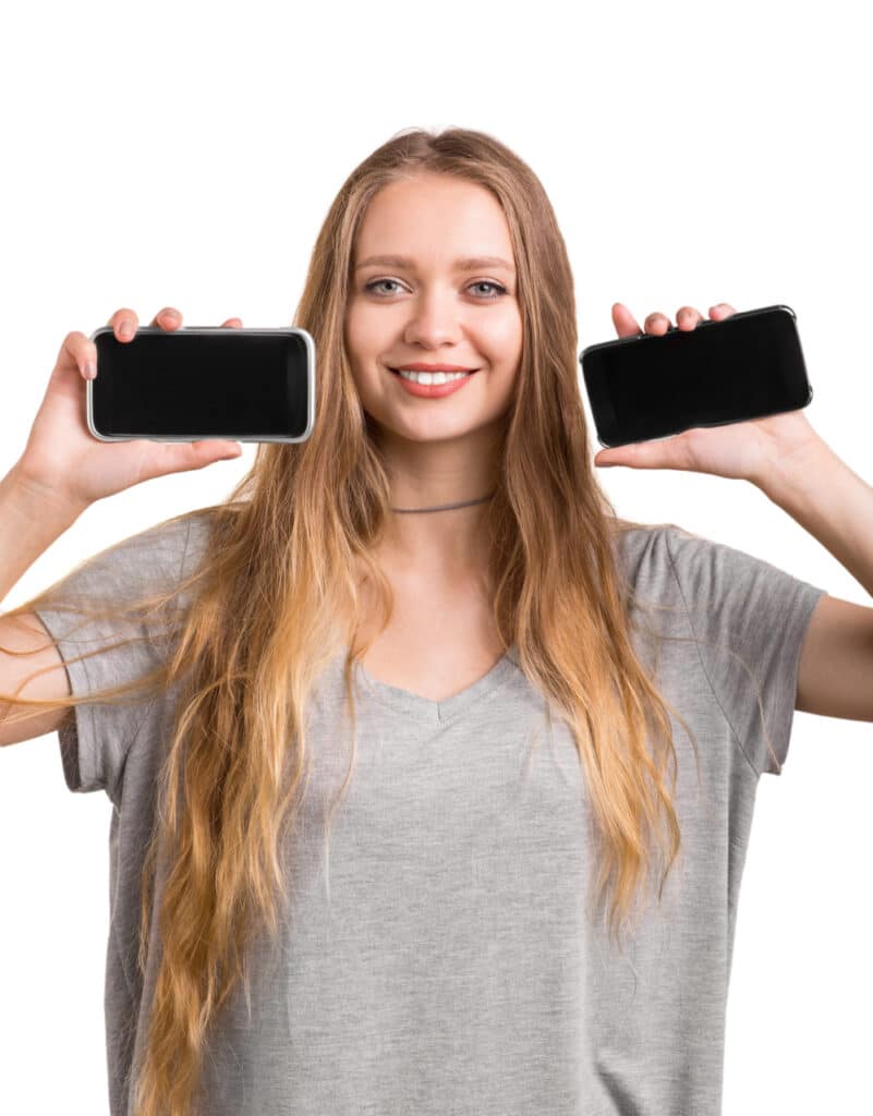 Photo of a young woman holding up two smartphones.
