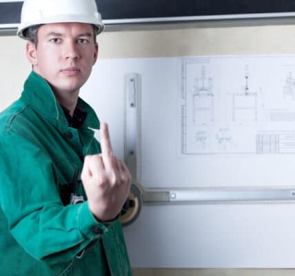 Photo of an engineer at a drafting board showing the middle finger to the camera.