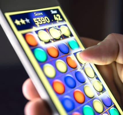 Up close photo of a hand playing a smartphone game.