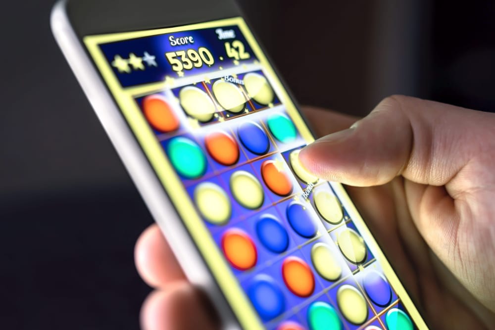 Up close photo of a hand playing a smartphone game.
