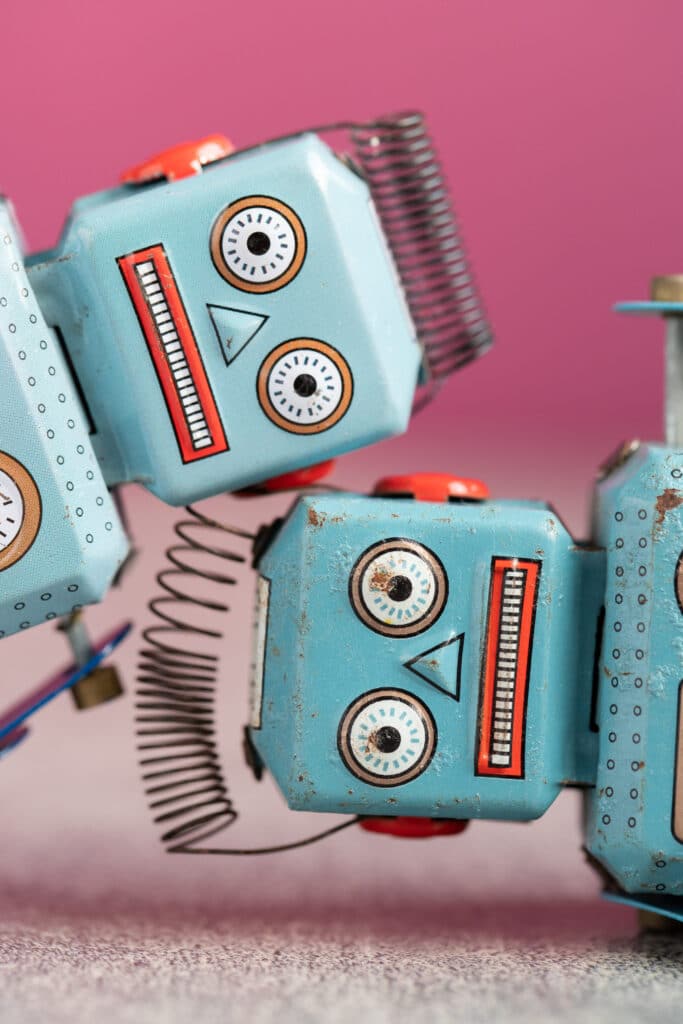 Photo of two vintage toy robots with distressed expressions.