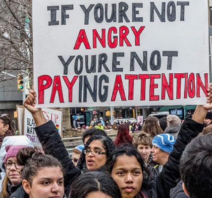 Photograph of protesters holding signs and marching.