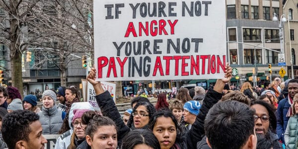 Photograph of protesters holding signs and marching.