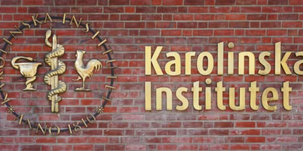 Photo of a brick wall containing the logo of the Karolinska Institutet.