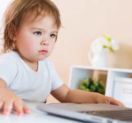 Photo of a child sitting in front of a computer.