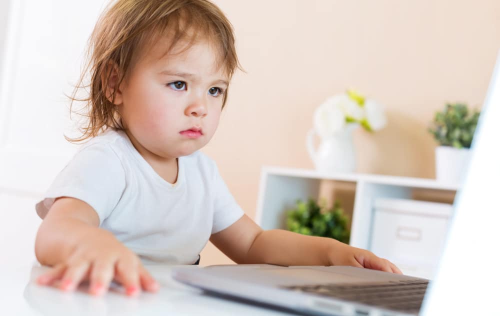 Photo of a child sitting in front of a computer.