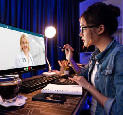 Photo of a young woman attending a weight loss coaching program through her computer.